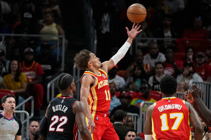 Apr 22, 2022; Atlanta, Georgia, USA; Atlanta Hawks guard Trae Young (11) scores a basket behind Miami Heat forward Jimmy Butler (22) during the first half of game three of the first round for the 2022 NBA playoffs at State Farm Arena.